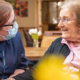 A care home resident with her carer