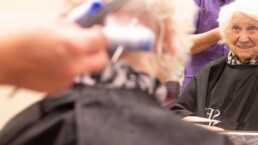 A resident having her hair done at Monson Care Home